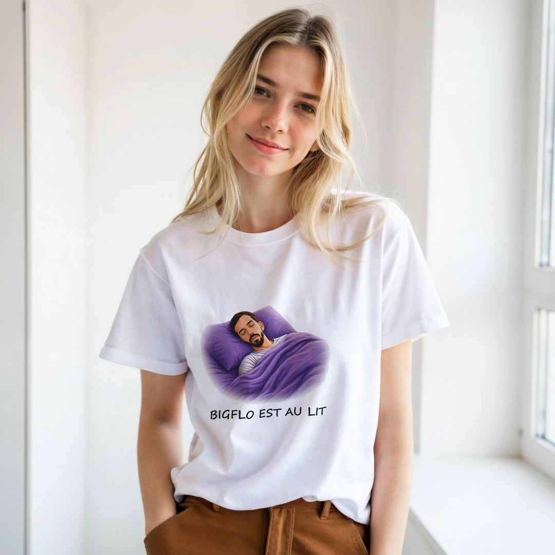 T-shirt femme « Bigflo est au lit » : un homme endormi, confortablement installé sous une couette violette, la tête posée sur un oreiller assorti.